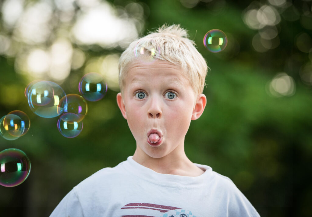 Boy with bubbles sticking tongue